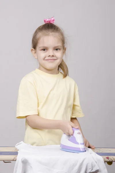 Meisje huisvrouw gestreken linnen — Stockfoto