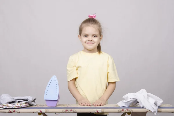 Chica se prepara para empezar a planchar ropa de cama —  Fotos de Stock