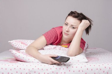 yorgun kız yatakta yatan ve tv izleme