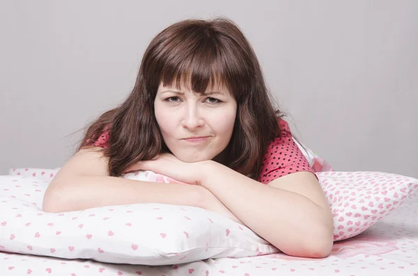 Unhappy girl lying in bed — Stock Photo, Image