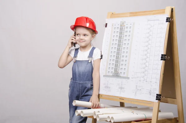 Het kind in helm praten over telefoon — Stockfoto