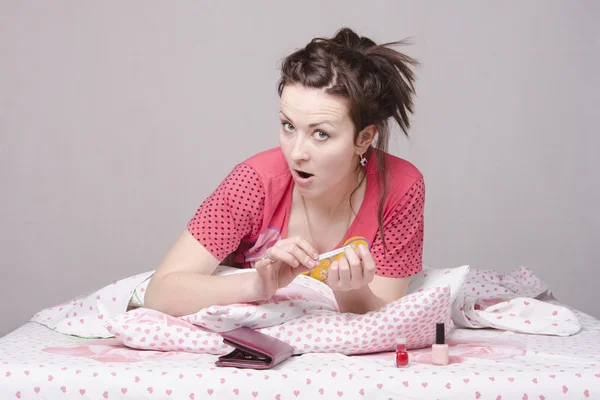 Meisje zorgt voor de nagels liggend in bed — Stockfoto