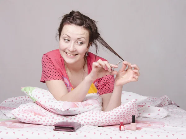 Girl cutting a lock of hair cuticle scissors — Stock Photo, Image