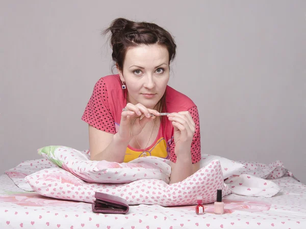 Girl has manicure lying in bed — Stock Photo, Image