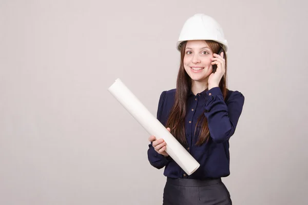 Designer talking on phone with blueprints in hand — Stock Photo, Image