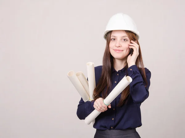 Architect talking on phone with blueprints in hand — Stock Photo, Image