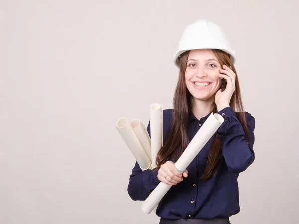 Engineer talking on phone with blueprints in hand — Stock Photo, Image