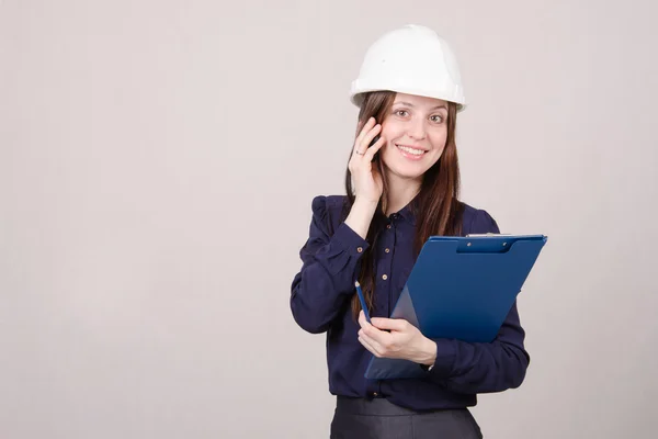 Woman in hard hat talking to a customer on phone — Stock Photo, Image
