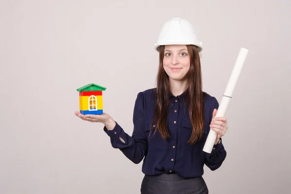 Meisje helm met huis waard en tekening in handen — Stockfoto