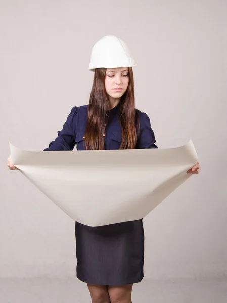 Girl in helmet looks a project expanding hands drawing — Stock Photo, Image