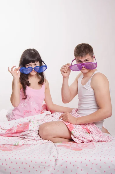 Young couple sitting in bed with big glasses — Stock Photo, Image