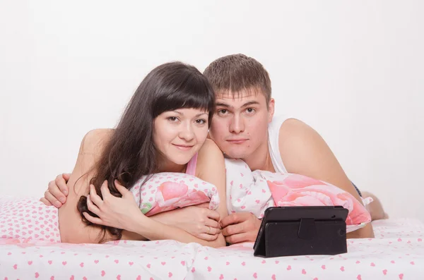 Pareja joven en cama con tableta — Foto de Stock