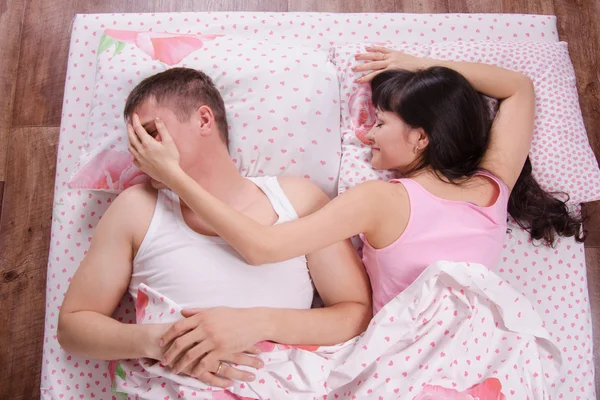 Hon lade handen på killens ansikte medan du sover i sängen — Stockfoto