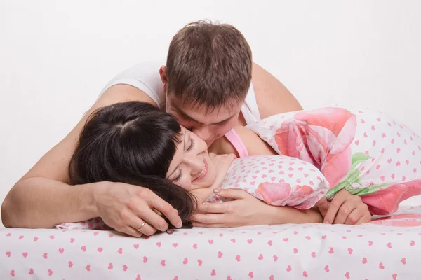 Lovers embrace and kiss in bed — Stock Photo, Image