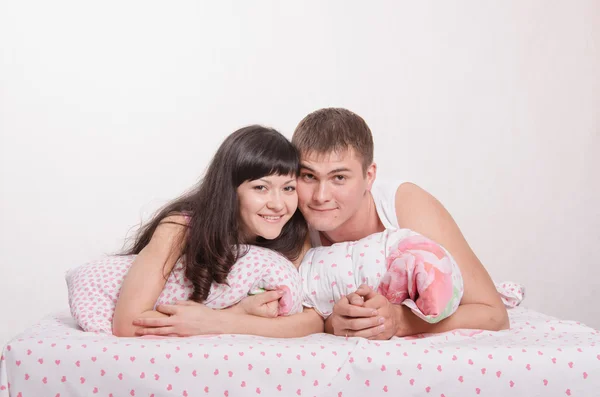 Meisje en jongen liggen omhelst in bed — Stockfoto