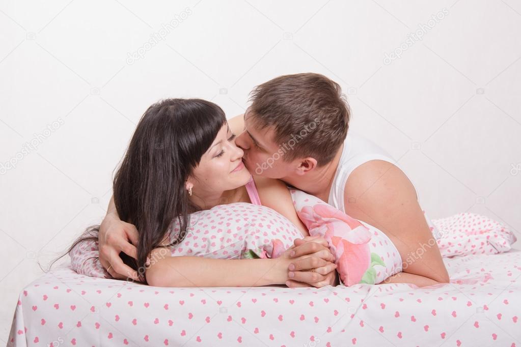 Young Boy Kissing A Girl In Bed Stock Photo C Madhourses