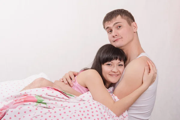 Young couple embracing in bed — Stock Photo, Image