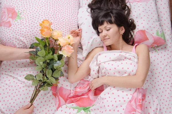 Slapende meisje gepresenteerd met een boeket rozen — Stockfoto