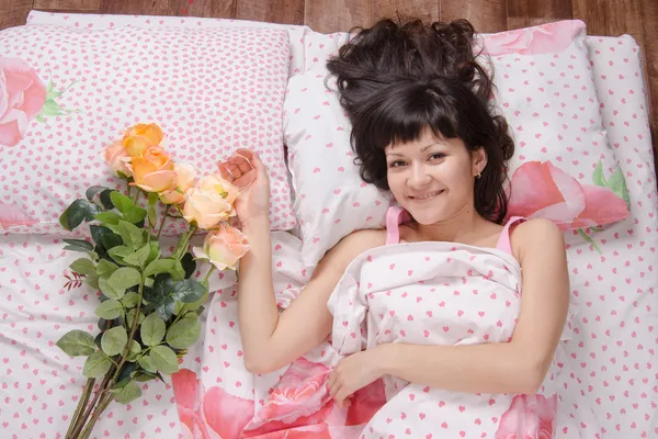幸せな少女の花のベッドの上 — ストック写真