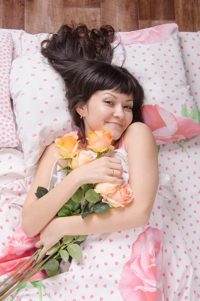 Schönes junges Mädchen im Bett liegend, froh, dass ihm Farben verliehen wurden — Stockfoto