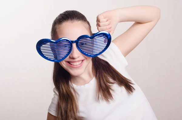 Twaalf jaar oud meisje met grote glazen in vorm hart — Stockfoto