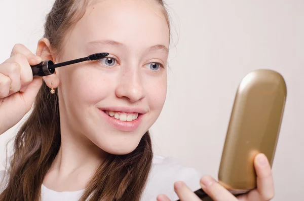 Tolv år gammal flicka målar ögonfransarna — Stockfoto