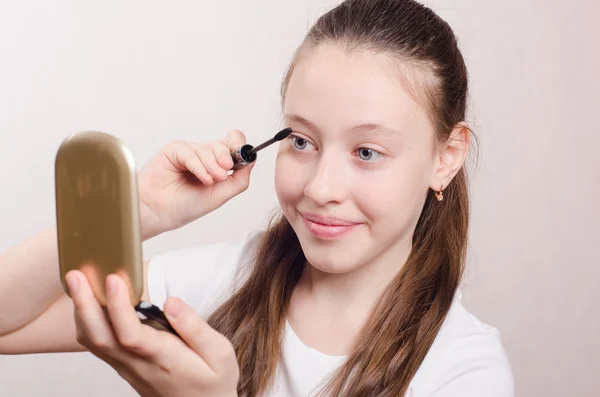 Teen flicka målar ögonfransarna — Stockfoto