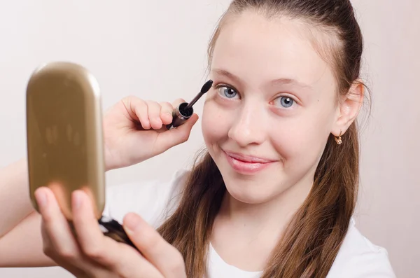 Happy teen girl paints eyelashes — Stock Photo, Image