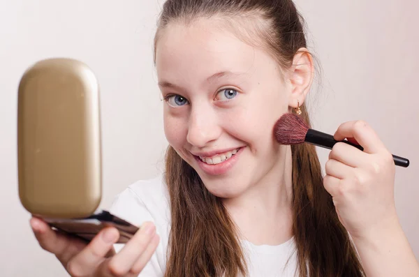 Twelve year old girl gets brush powder on cheek — Stock Photo, Image