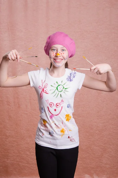 Gelukkig vrolijke meisje met een geschilderde verf penselen — Stockfoto