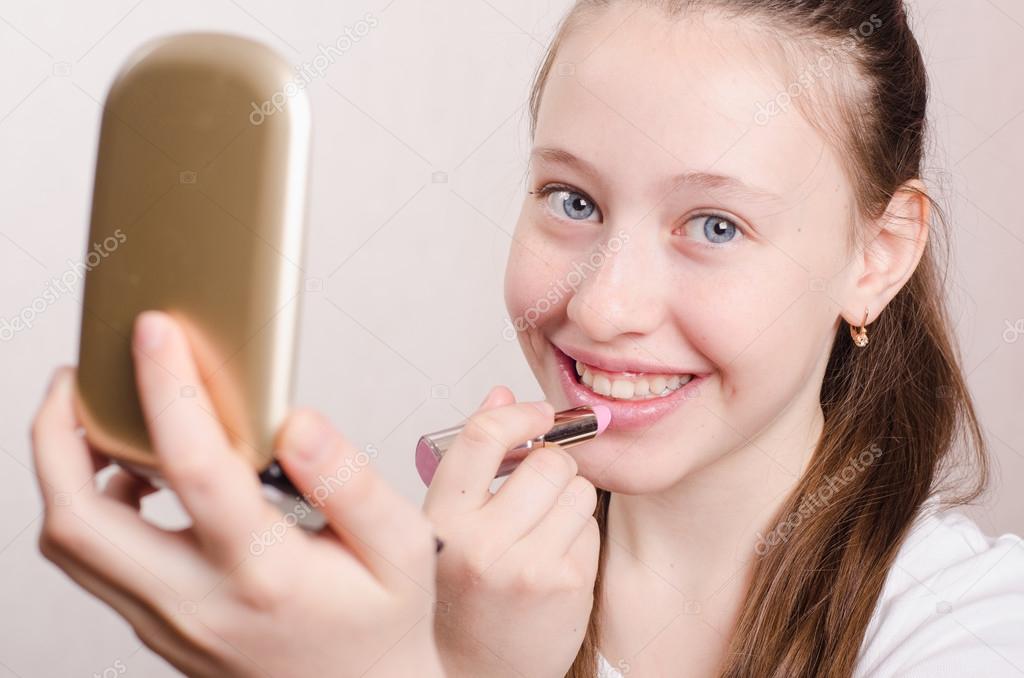 Teen girl paints lips with lipstick — Stock Photo © Madhourses 45941143