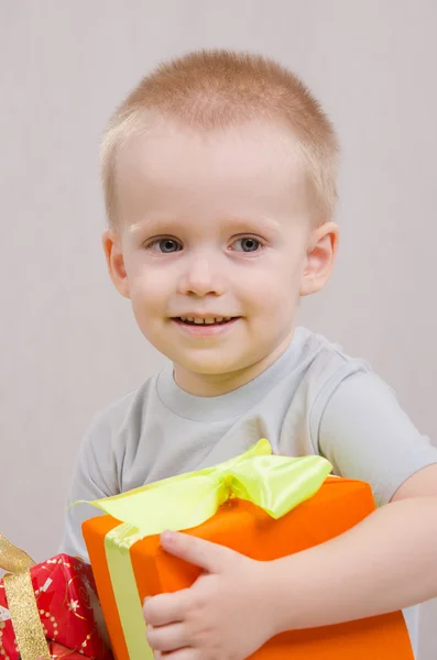 Niño de un año con un regalo se ve bien — Foto de Stock