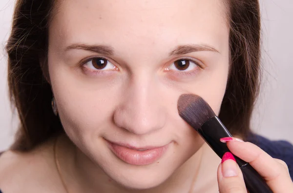 Makeup artist is shaded concealer brush on face model — Stock Photo, Image