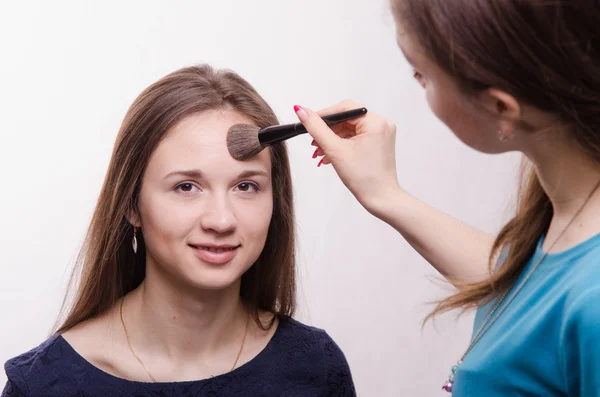 Makeup artist gets fluffy powder brush on forehead model — Stock Photo, Image