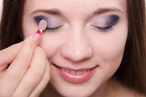 Make-up artiest is gearceerd oogleden mooi meisje — Stockfoto