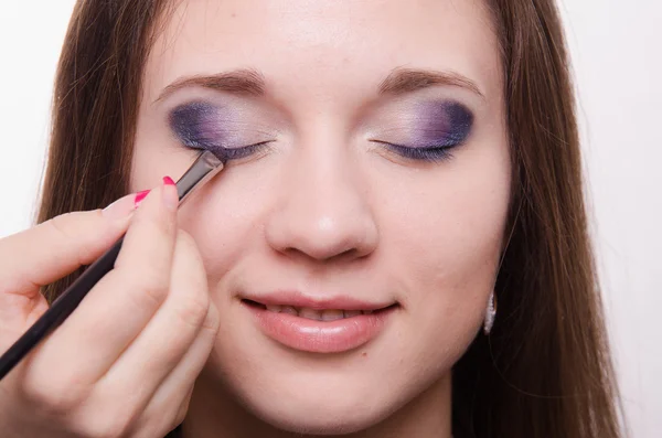 Artista de maquillaje embellecer las pestañas de una hermosa chica —  Fotos de Stock