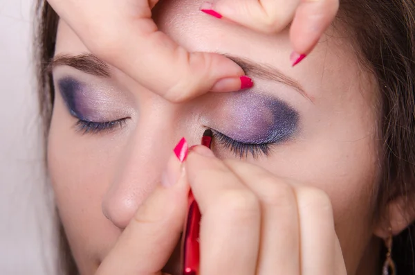 Makeup artist brings pencil eyelashes girl — Stock Photo, Image