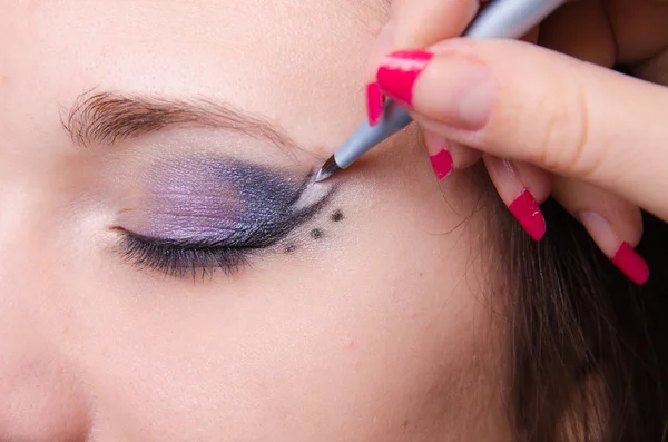 Maquillaje artista dibuja flechas en las niñas blancas edades —  Fotos de Stock