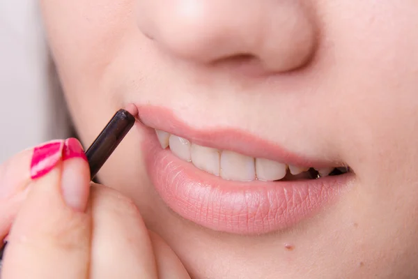 Makeup artist paints a lip pencil woman — Stock Photo, Image