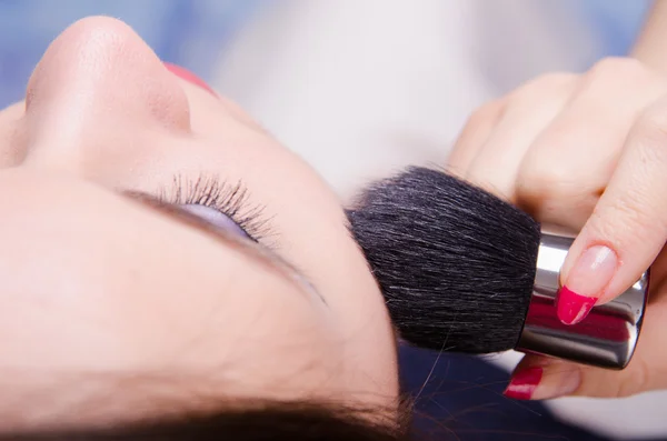 Makeup artist powders face of a beautiful girl — Stock Photo, Image