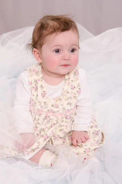Menina de seis meses sentada em tule — Fotografia de Stock