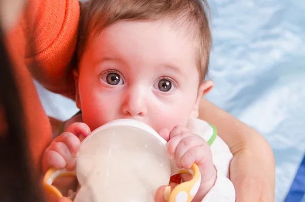 Six-month girl drinks milk from a bottle — Stock Photo, Image