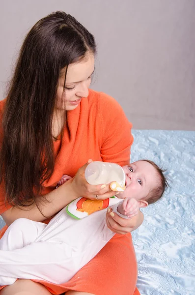 Young mother feeding bottle six-month baby girl — Stock Photo, Image