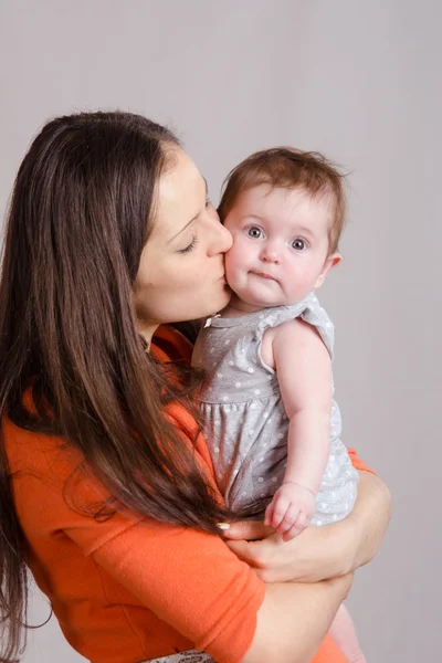 Young happy mother kissing her daughter — Stock Photo, Image