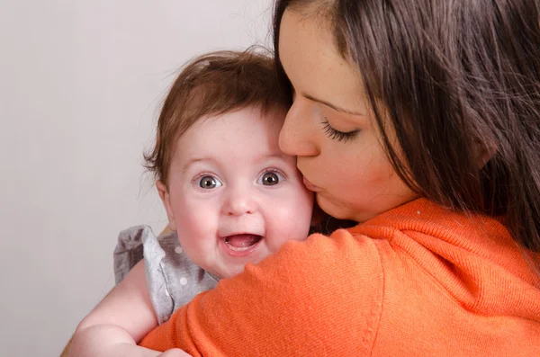 Mãe beija uma filha de seis meses — Fotografia de Stock