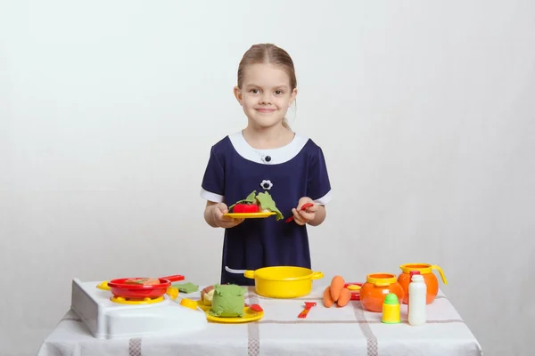 Fünfjährige hält Teller mit Schüssel und Löffel — Stockfoto