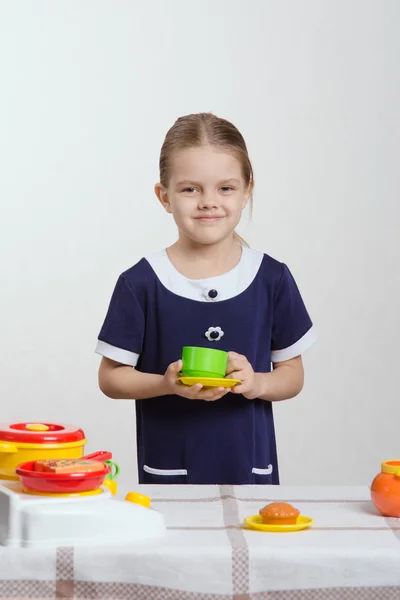 Chica jugando en la vajilla de los niños — Foto de Stock