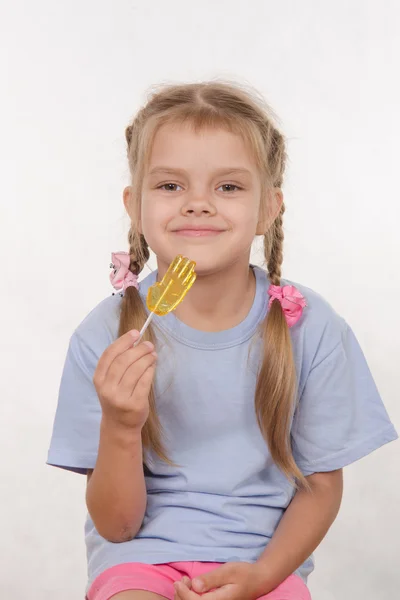 Cheerful five year old girl with a lollipop — Stock Photo, Image