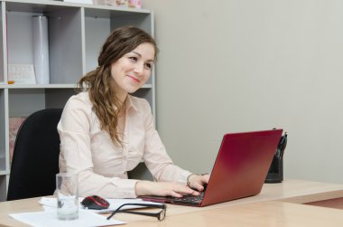 bir dizüstü bilgisayar ofiste çalışan genç kız