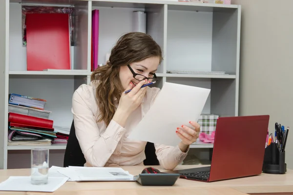 Chica ríe mientras lee un documento en el lugar de trabajo — Foto de Stock